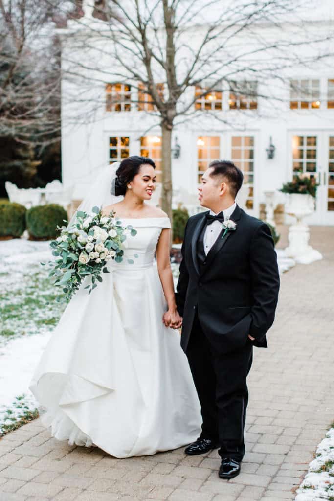 bride and groom walking down the path on the snowy day