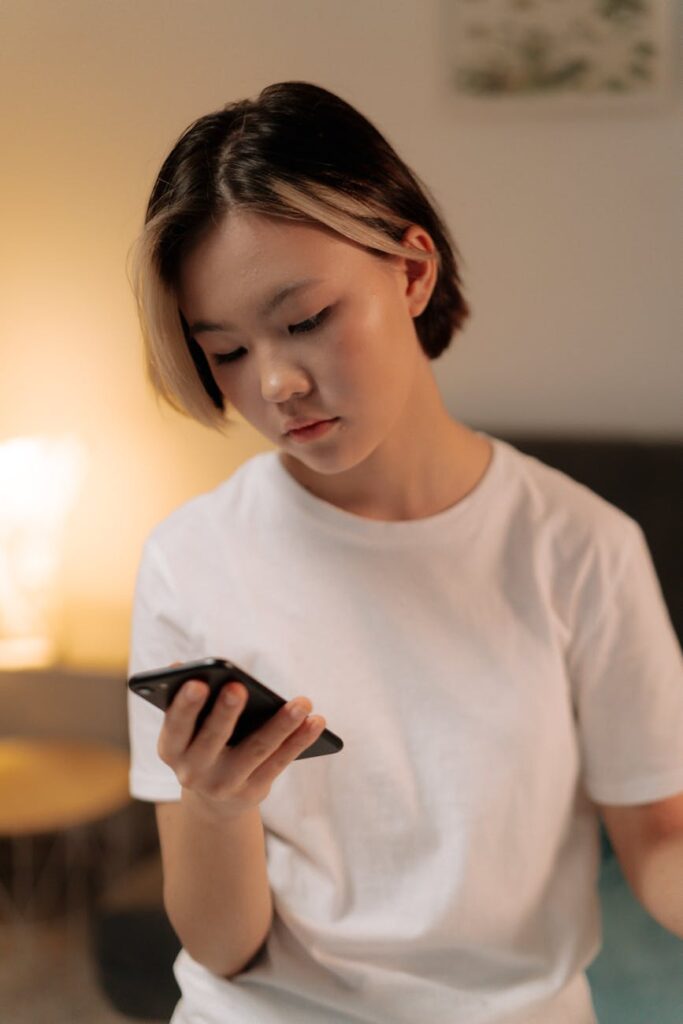 a woman in white shirt using a smartphone