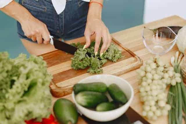femme coupant des légumes