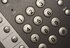 Close-up of a keypad with round gray number keys labeled with letters (2–9) and adjacent function keys visible on a textured surface