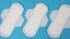 Several white sanitary pads arranged diagonally on a bright blue background.