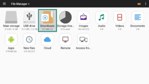File Manager + app interface on Android TV, showing the main screen and a highlighted "Downloads" option.
