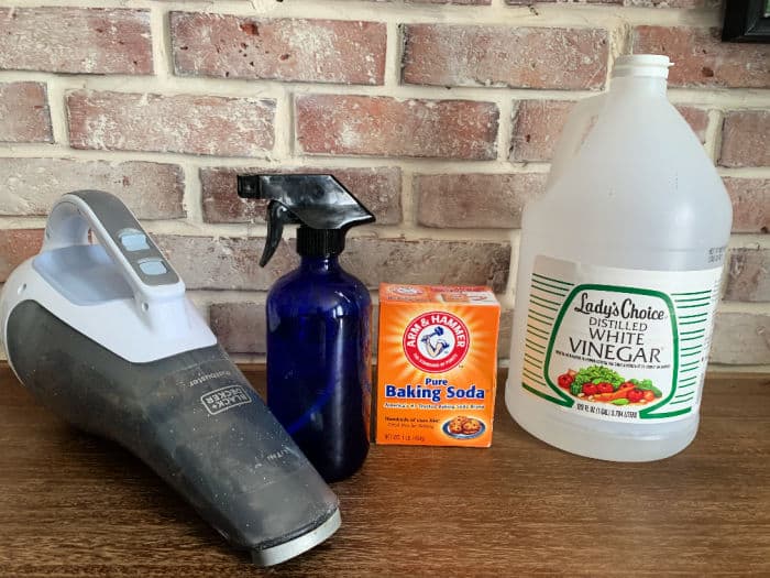 Supplies to clean a mattress: vinegar, baking soda, spray bottle and vacuum.