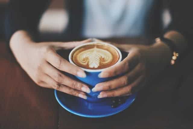 une tasse de café tenue dans vos mains