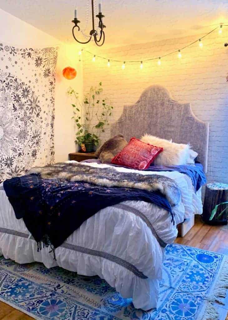 string lights above the bed in hygge bedroom