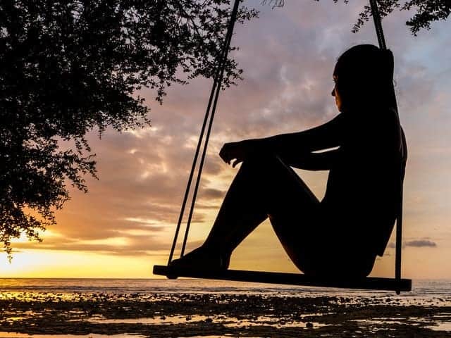 une femme triste sur une balançoire