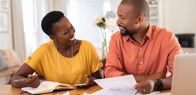 Couple smiling while planning and budgeting