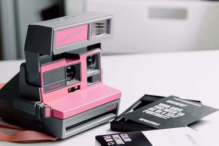 polaroid camera with film on white table