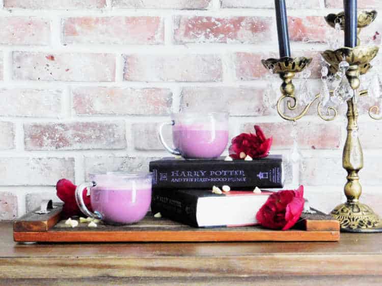 two cups of amortentia love potion sitting on top of harry potter novel
