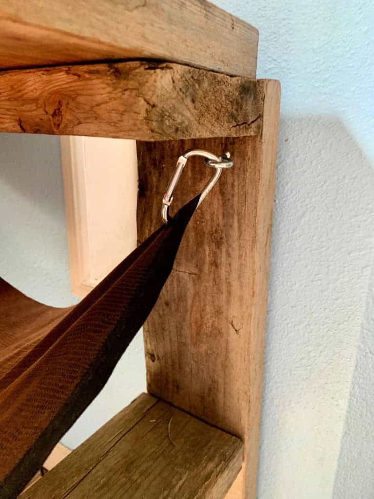 eye hook with carabiner attached to hang fabric hammock under the table