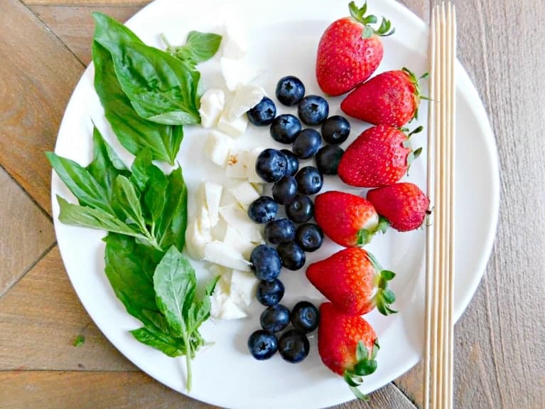 Plate of berries, basil and cheese.