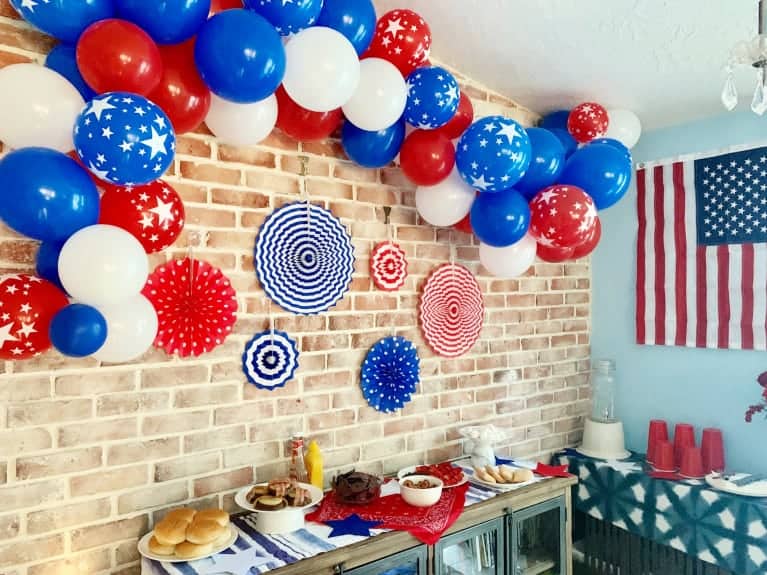 red white and blue balloons hung over a usa themed tablescape