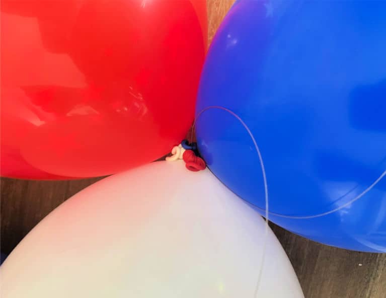 red white and blue balloons tied together