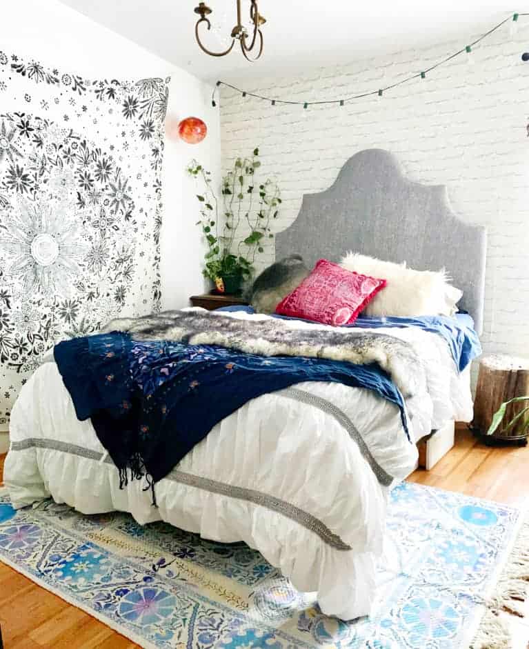 hygge bedroom with beautiful wall hanging and bright colored pillows