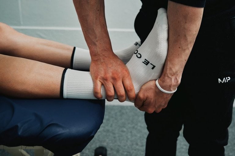 A sports therapist assessing an ankle joint at seventy9 Sports Therapy, a sports injury clinic in Guildford