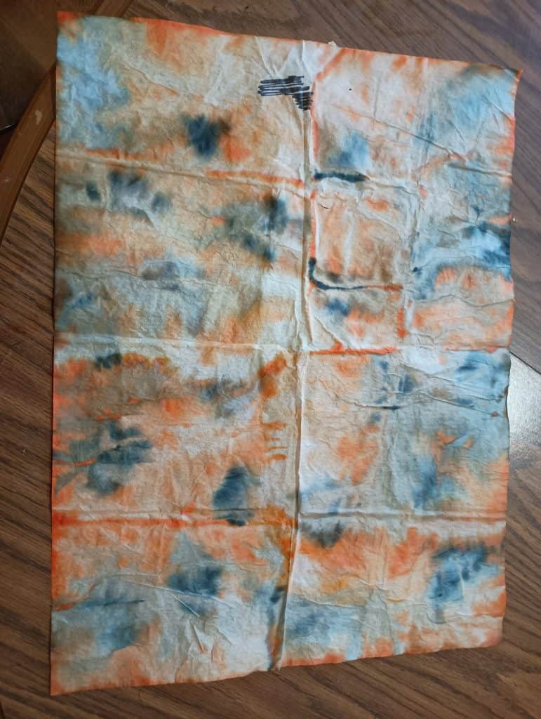 Picture of a piece of tissue paper tie dyed orange and black