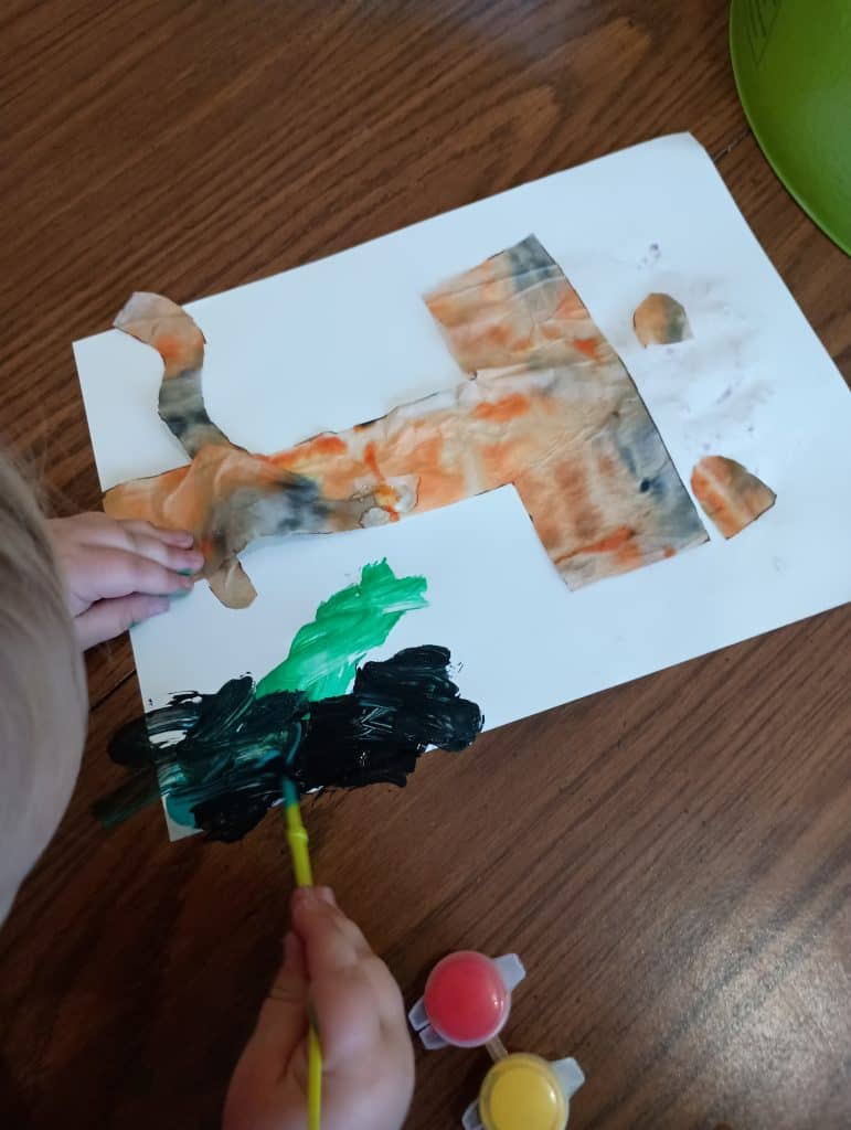Picture of a toddler painting around a T is for tiger craft
