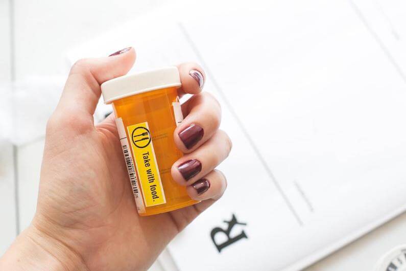 picture of person holding pill bottle of opiates