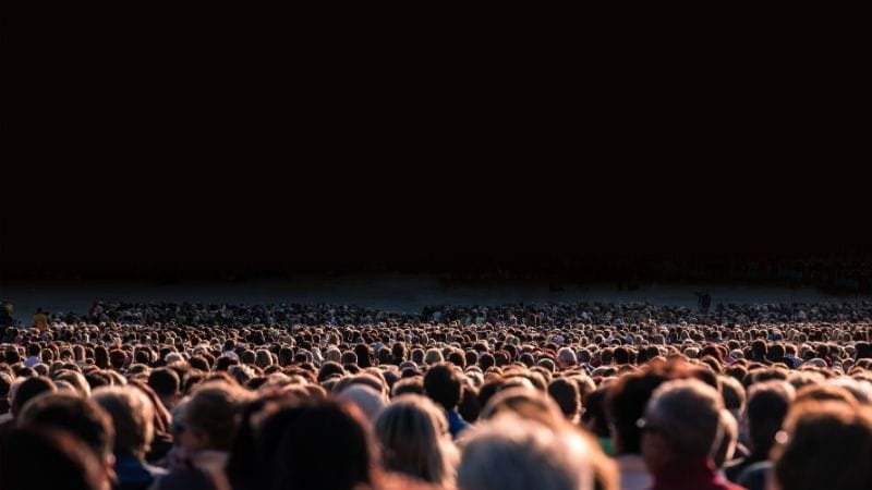 crowd of people waiting for a motivational speaker to appear.