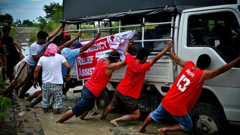 Bayanihan is community volunteerism. In this picture of bayanihan, the community is helping a truck for relief operations get out of muddy road.