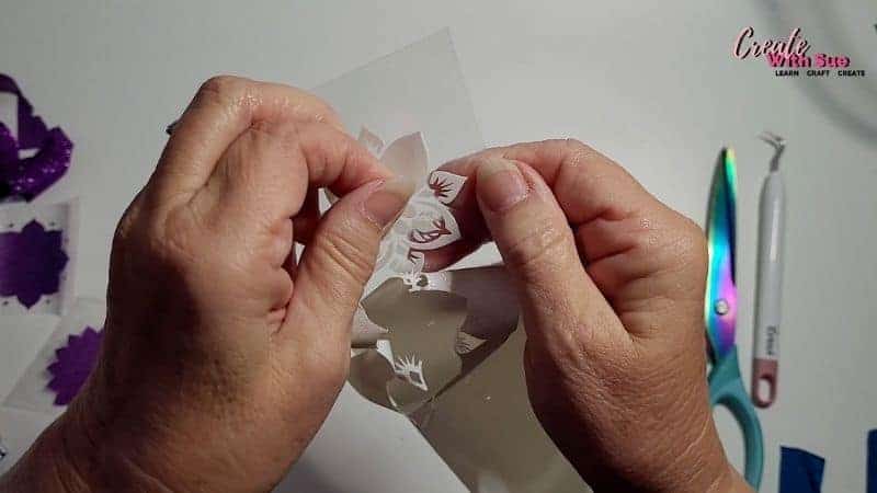 Weeding the HTVRont white glitter mandala design