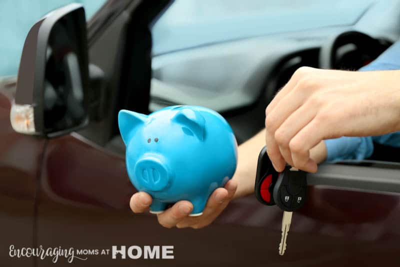 Man holding piggy bank and key in his new car