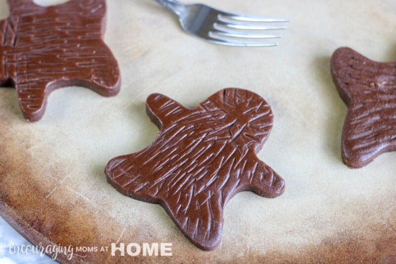 Creating hair on the cutout cookies with a fork.