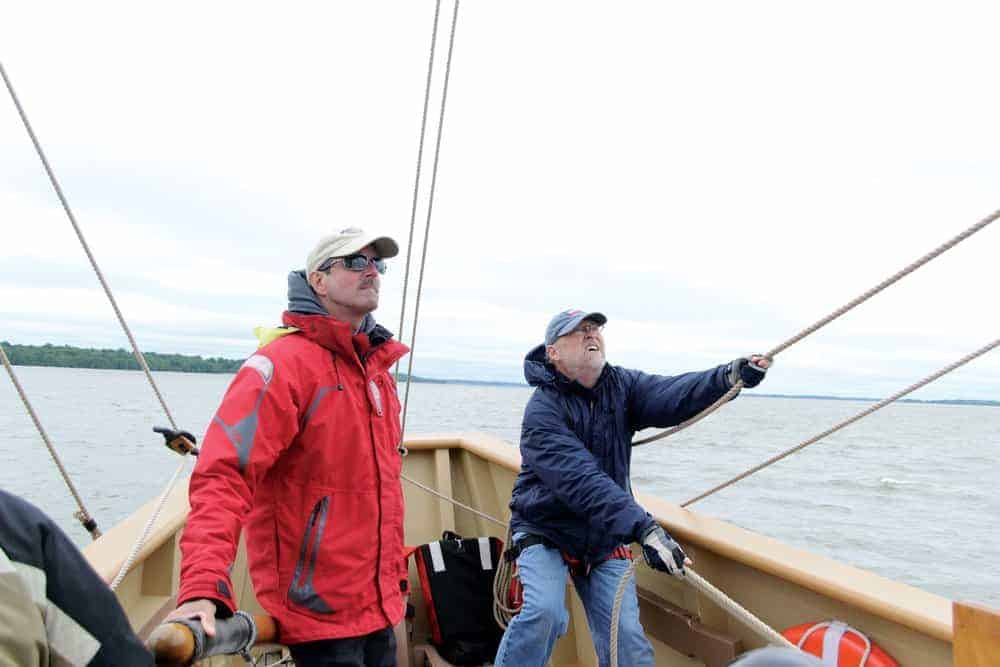 Captain Eric Speth (left) and volunteer Russ Sage (right) guide the 17th century replica vessel Godspeed along the James River.- photo Karen Soule
