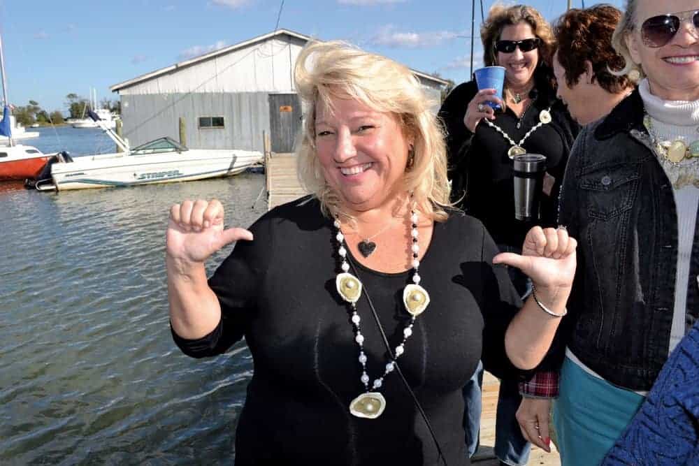 Frying fritters with the Middlesex Lions Club (top); and an oyster-festival goer showing off her bivalve-themed jewelry. - photo by karen soule photos