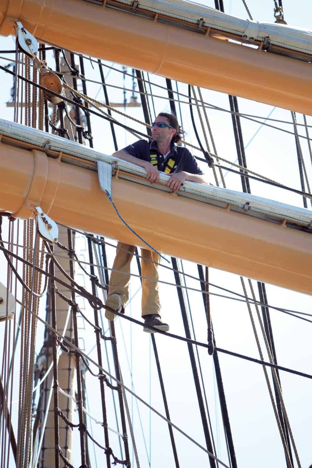 Sailmaker Justin Ailsworth aloft on the Eagle . Photo by Karen Soule.