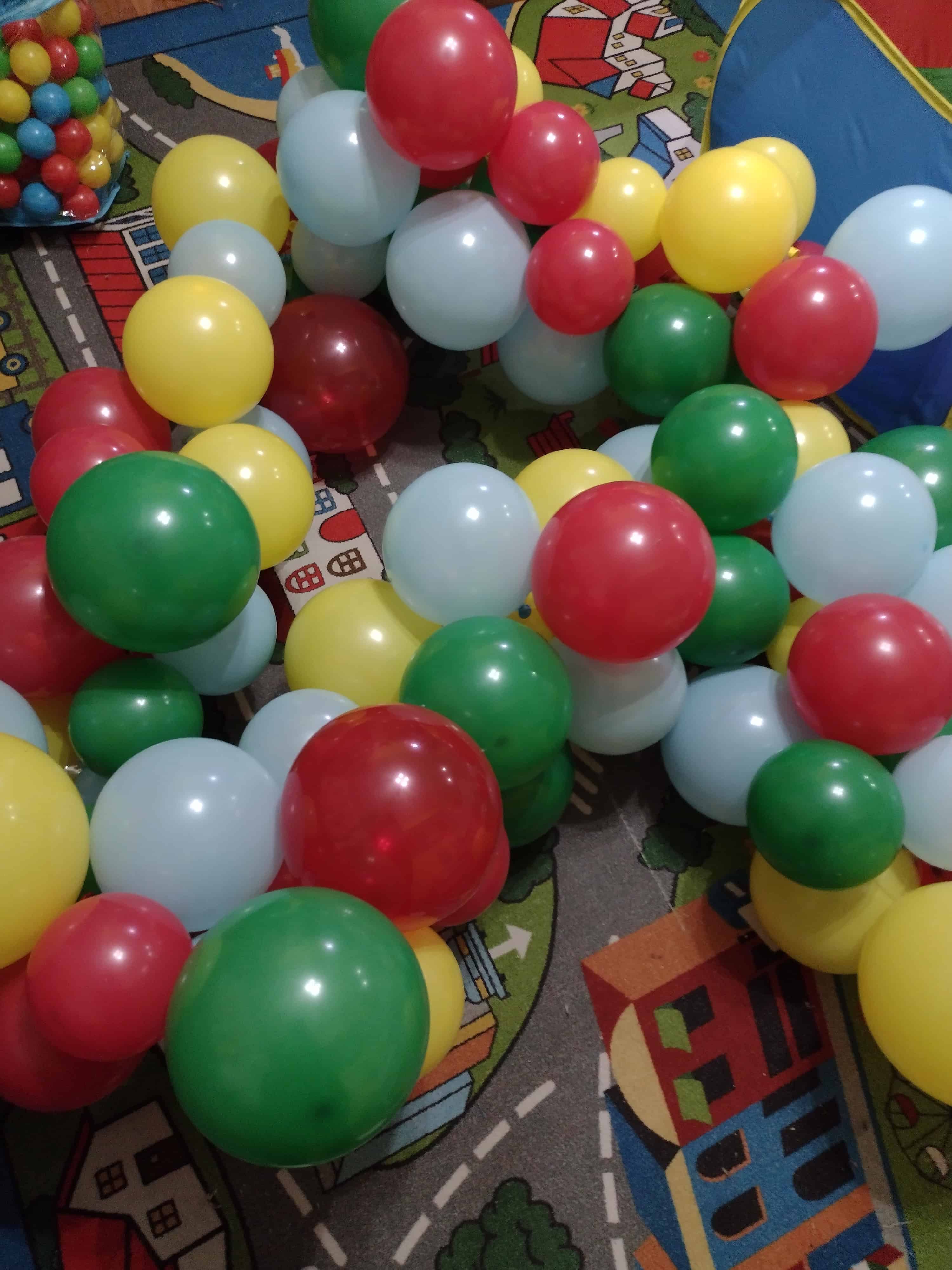 Picture of a pile of balloons attached to balloon tape sitting on the ground