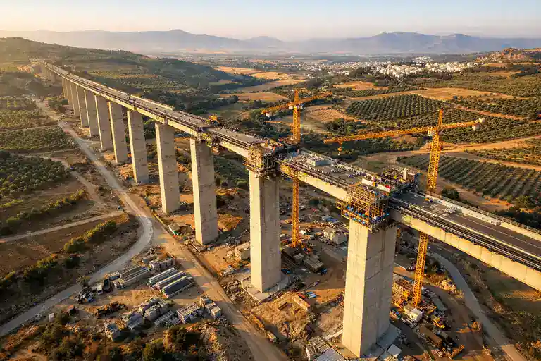 Viaducto ferroviario en construcción visto desde drone aéreo profesional con luz dorada