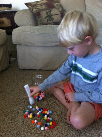 Elementary school child teaches his brother a game to improve fine motor skills.