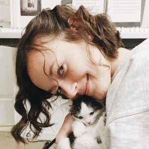 Music City Cats cat sitter cuddling with a kitten Music City Cats cat sitter cuddling with a black and white kitten