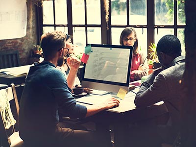 Four Employees of Startup Company Meeting in Small Office to Discuss Business Communication Solutions