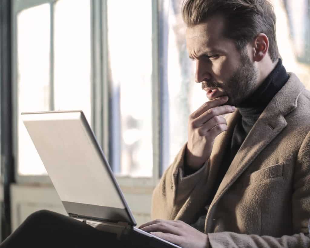 man intently looking at laptop