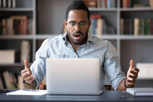 man surprised while working at laptop