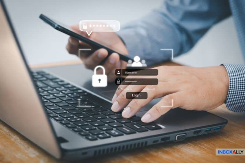 Uma pessoa usa um smartphone e digita em um teclado de laptop, com ícones de login digital e gráficos de segurança de senha exibidos ao lado das configurações de SMTP da GoDaddy para acesso seguro a e-mails.