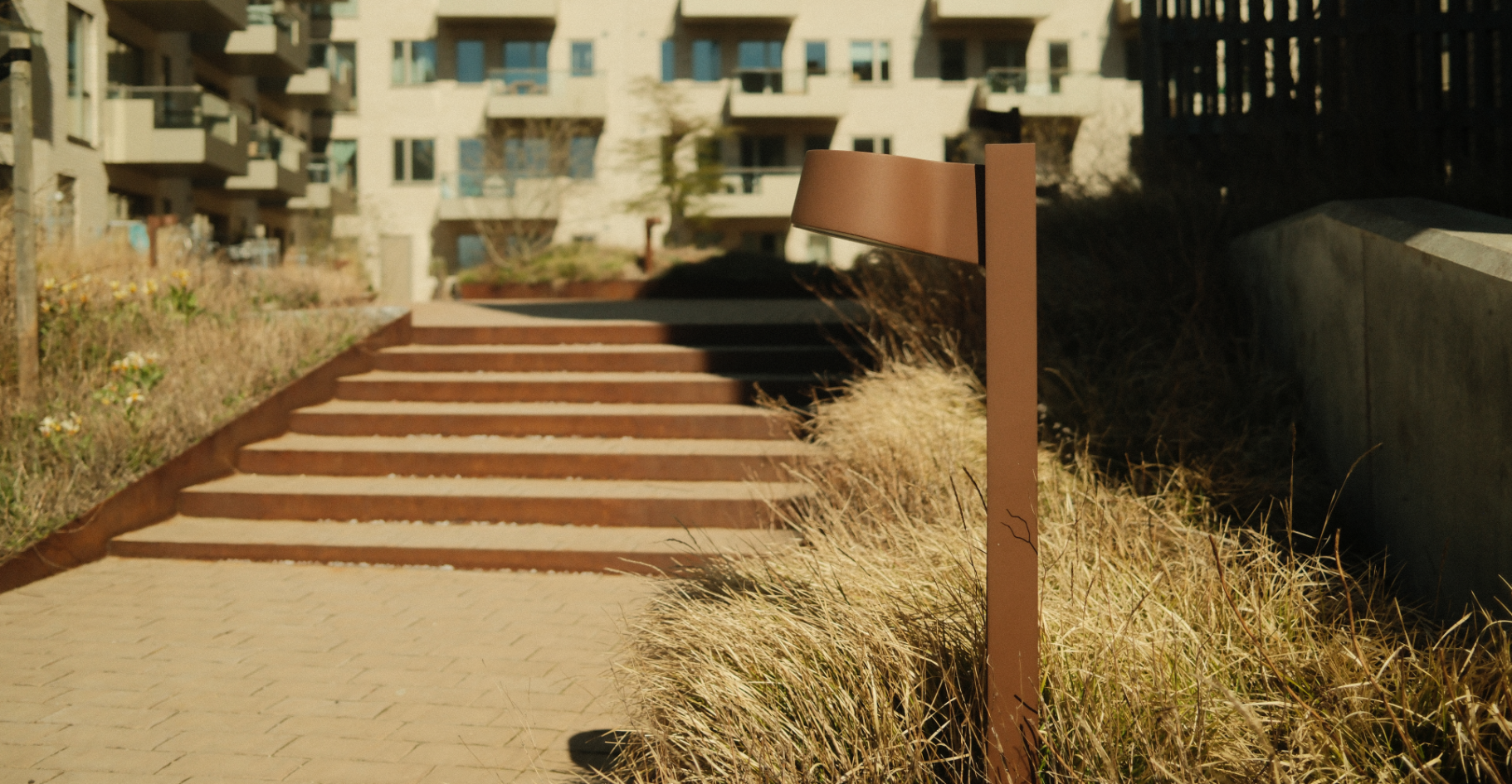 Brown-coloured lighting columns alongside outdoor steps
