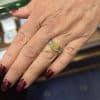 Elegant yellow gemstone ring on a woman's finger.