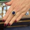 Sapphire and diamond ring on a woman's finger at Weldons Jewellers.