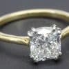 Engagement ring with a large cushion-cut diamond set in a gold band.