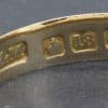 Close-up of gold ring hallmarks showing purity and maker's marks.