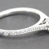 Silver engagement ring with a large central diamond and smaller diamonds along the band.