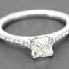 Diamond engagement ring with a square-cut center stone and pavé band.