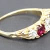 Gold ring featuring central ruby and surrounding diamonds, fine jewelry piece.