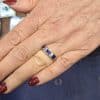 Close-up of a woman's hand wearing a sapphire and silver ring at Weldons Jewellers.