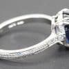 Silver ring featuring a large, deep blue gemstone and intricate engraved band design.