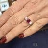 Ruby and diamond engagement ring on a woman's hand.