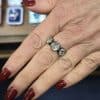 Diamond ring with multiple sparkling stones on a woman's finger.